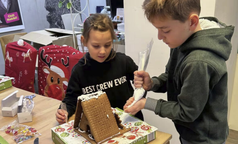 Gelnhausen lebkuchenhaus wird von kindern mit zuckerguss verziert